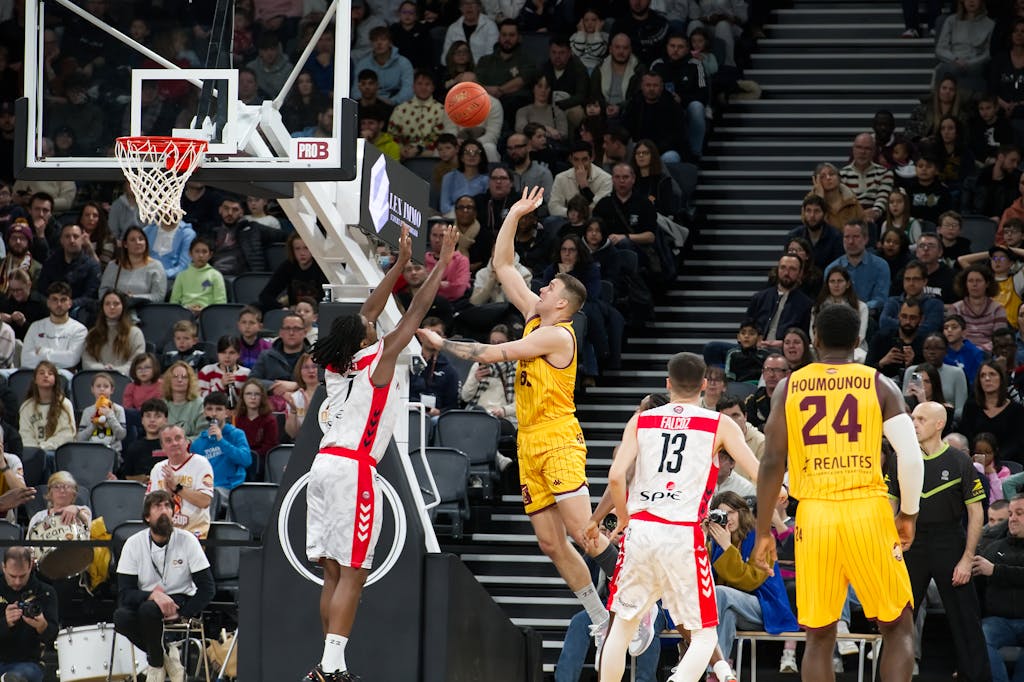 Dramatic moment in a basketball game with players and an engaged crowd.