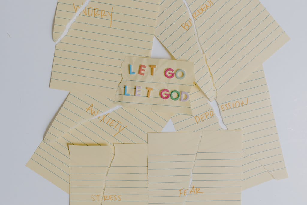Flat lay of torn notes with an inspirational 'Let Go, Let God' message.
